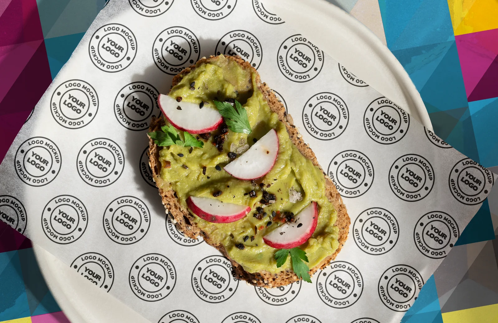 Avocado toast on JNS custom wax paper over a colorful geometric tablecloth